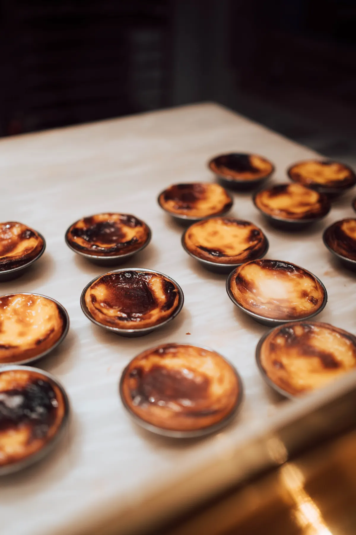 Pastéis de nata recién hechos en el mostrador de una pastelería de Lisboa