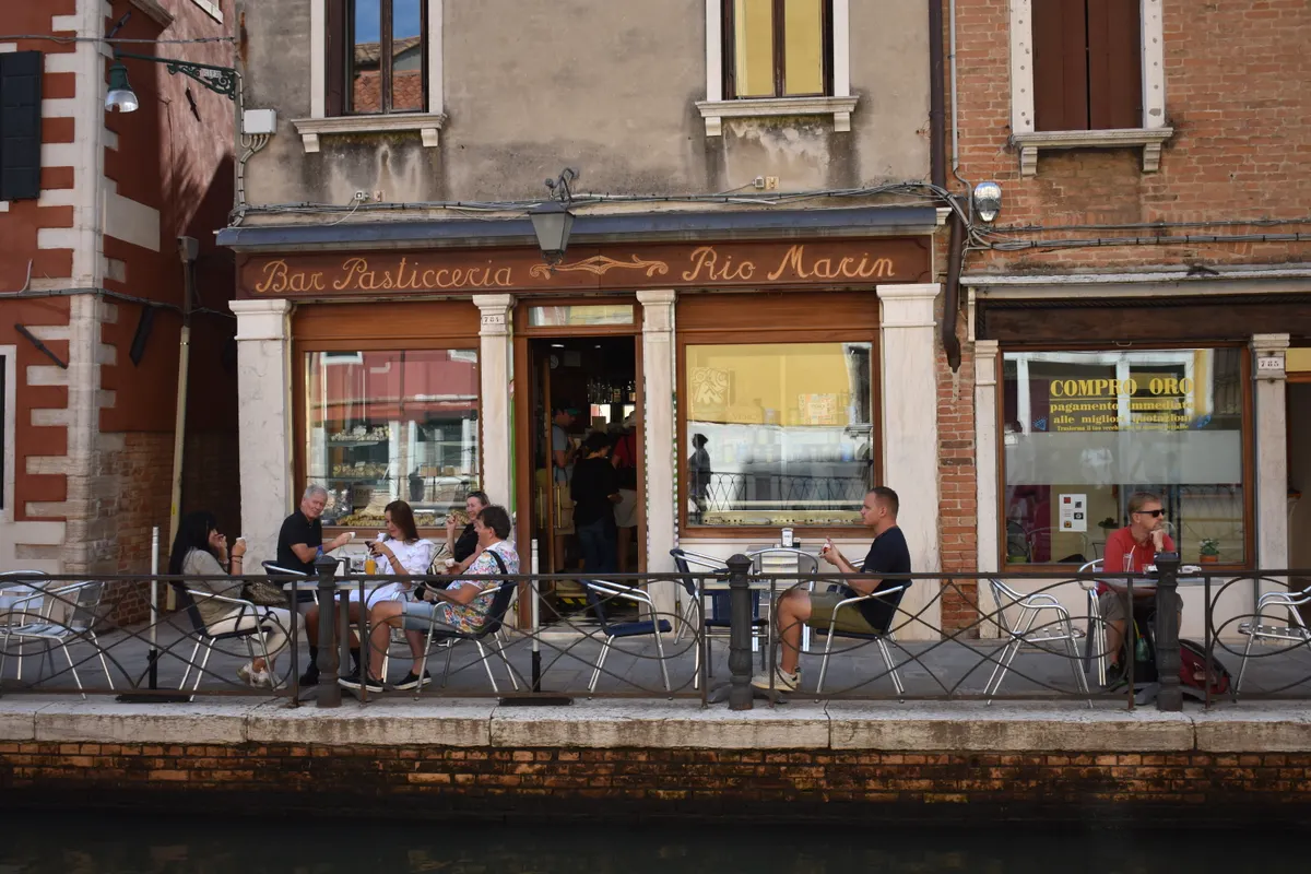 Terraza de un café junto a un canal de Venecia