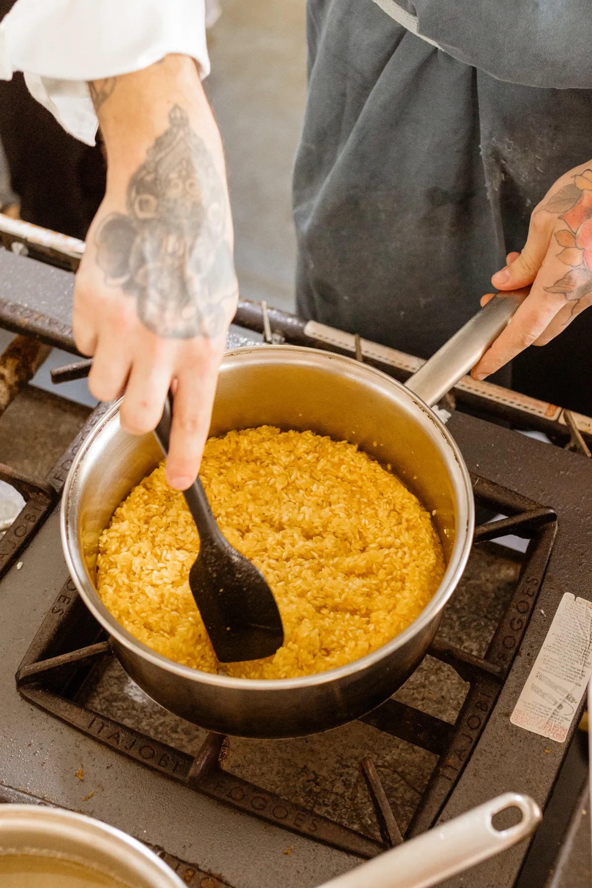 Un cocinero removiendo un risotto con azafrán