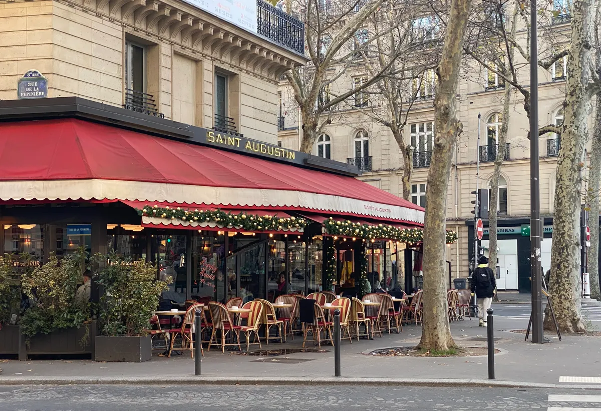 Terraza de un café parisino con toldo rojo