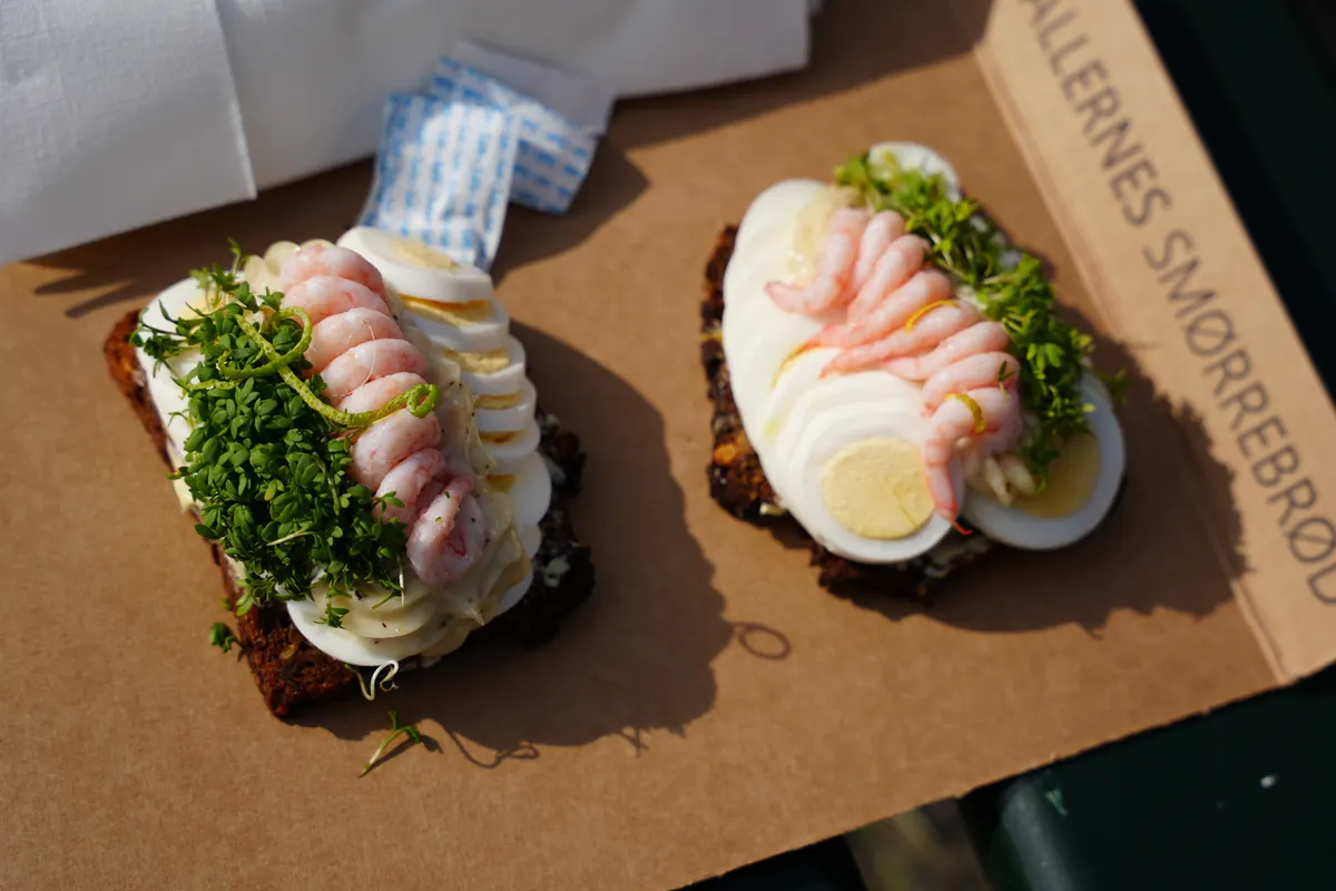 Smørrebrød tradicional danés con gambas y huevo sobre pan de centeno